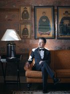 九门2男主角形象剧照，身着民国长袍，神情深沉，背景为古朴建筑